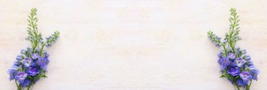 Beyaz, eski, ahşap arka planda bir buket mavi çiçek. Üst görünüm, düz uzanma