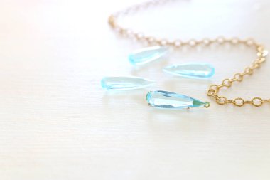 Hassas mavi taşlar beyaz ahşap arka plana düşer.