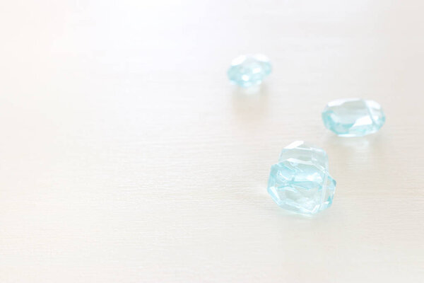 Delicate blu gemstones beads on white wooden background