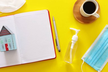 Merkez ofisin konsept imajı. Covid-19 Coronavirus karantinası. Sarı arkaplanda boş defter var.