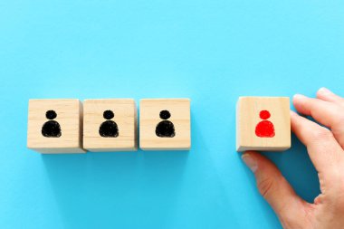 Sosyal uzaklığın konsept görüntüsü. Tahta bloklar ve insan simgeleri, kalabalıktan bir kişi ayrıldı. Covid 10 virüsünün enfeksiyonunu önlemek