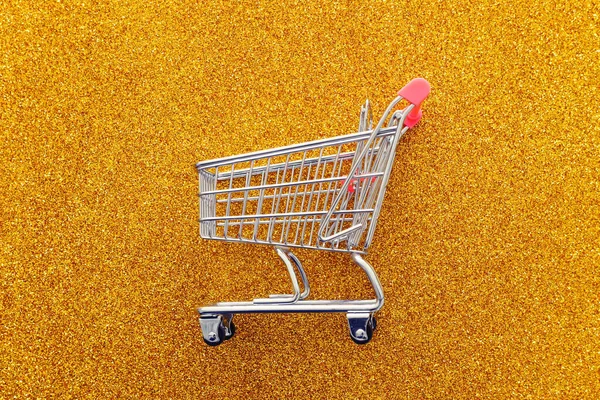 金の輝きを背景にショッピングカートのイメージ — ストック写真