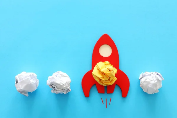 education or innovation concept. Wooden rocket over blue background