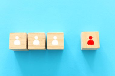 Sosyal uzaklığın konsept görüntüsü. Tahta bloklar ve insan simgeleri, kalabalıktan bir kişi ayrıldı. Covid 10 virüsünün enfeksiyonunu önlemek