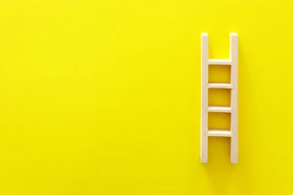黄色の背景に木製のはしご — ストック写真