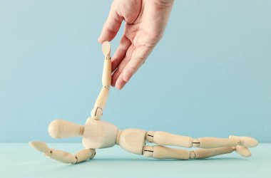 Yardım eli ve destek konsepti. Erkek, ahşap kuklaya yardım ediyor. Bela ve stres metaforu