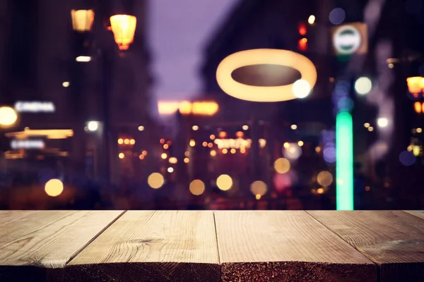 background Image of wooden table in front of street abstract blurred lights view