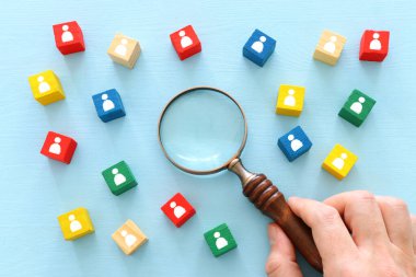 Ahşap masa, insan kaynakları ve yönetim kavramının üzerinde insan simgeleri olan renkli blokların görüntüsü