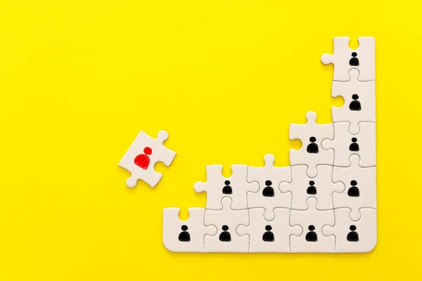 image of puzzle pieces with people icons over yellow background ,human resources social distancing and management concept