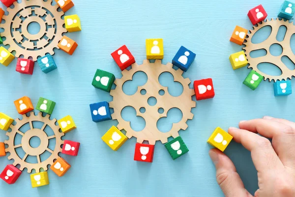 image of colorful blocks with people icons over wooden table ,human resources and management concept