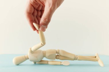 Yardım eli ve destek konsepti. Erkek, ahşap kuklaya yardım ediyor. Bela ve stres metaforu