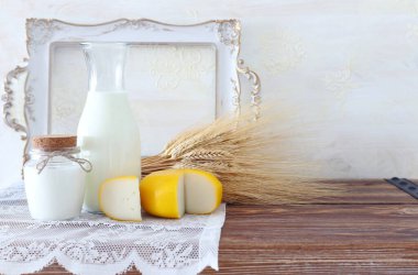 Eski ahşap masa ve beyaz arka planda süt ürünlerinin fotoğrafı. Yahudi bayramının sembolleri - Shavuot