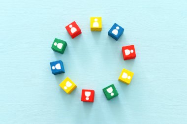 Ahşap masa, insan kaynakları ve yönetim kavramının üzerinde insan simgeleri olan renkli blokların görüntüsü