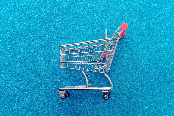 青い輝きの背景にショッピングカートのイメージ — ストック写真