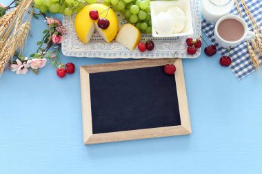 Süt ürünlerinin mavi arka plandaki en iyi görüntüsü. Yahudi bayramının sembolleri - Shavuot