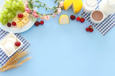 Süt ürünlerinin mavi arka plandaki en iyi görüntüsü. Yahudi bayramının sembolleri - Shavuot