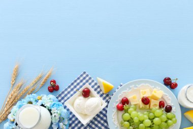 Süt ürünlerinin mavi arka plandaki en iyi görüntüsü. Yahudi bayramının sembolleri - Shavuot
