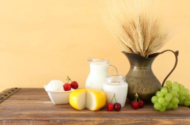 Eski ahşap masa ve pastel arka planda süt ürünlerinin fotoğrafı. Yahudi bayramının sembolleri - Shavuot