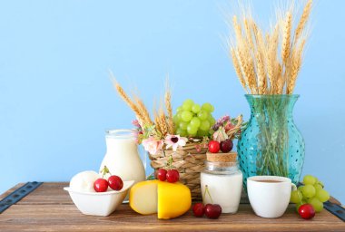 Eski ahşap masa ve pastel arka planda süt ürünlerinin fotoğrafı. Yahudi bayramının sembolleri - Shavuot