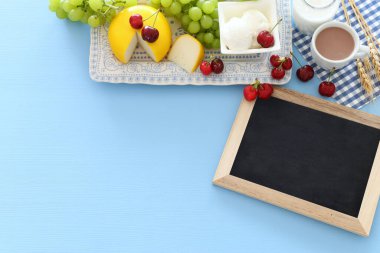 Süt ürünlerinin mavi arka plandaki en iyi görüntüsü. Yahudi bayramının sembolleri - Shavuot