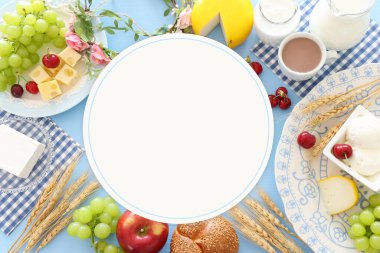 Süt ürünlerinin mavi arka plandaki en iyi görüntüsü. Yahudi bayramının sembolleri - Shavuot