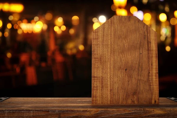 背景抽象的なぼやけたレストランライトの前の木製テーブルの画像 — ストック写真
