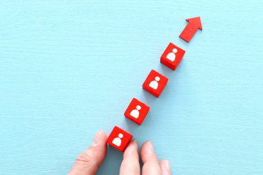 Ahşap masa, insan kaynakları ve yönetim kavramının üzerinde simgeler bulunan ahşap kırmızı küplerin iş imajı