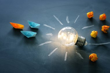 Eğitim ve liderlik kavramı imajı. Yaratıcı fikir ve yenilik. Tahta üzerinde metafor olarak ampul