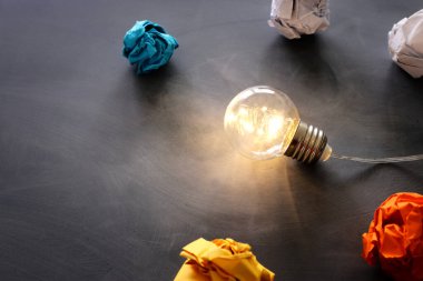 Education concept image. Creative idea and innovation. Light bulb as metaphor over blackboard clipart