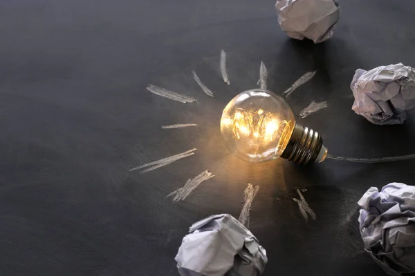 Education concept image. Creative idea and innovation. Light bulb as metaphor over blackboard