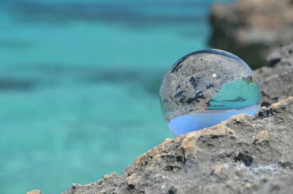 Crystal glass sphere on stone rocks