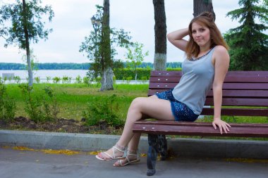 Kız bankta oturuyor.