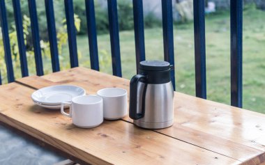 Kafenin balkonunda beyaz renkli boş tabaklar, kahve fincanları ve izole edilmiş sıcak içecek kabı. Yer Ayarlama. Al fresco yemeği. Yüksek melek tarafı görünümü.