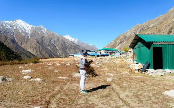 A solo traveler hobbyist musician playing guitar alone in the silence of Himalayan mountain valley and sound of guitar strings. Summer music Inspiring environment in outdoors. Sangla India South Asia.