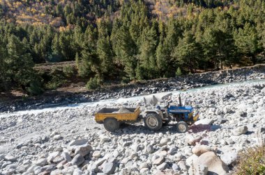 İnşaat şantiyesi atık kamyonu kamyon kamyon ağır yük kapasiteli toprak kaya kumları ve nehir kenarındaki kayalar uzak Himalayas Spiti Vadisi, Hindistan Asya Mayıs 2019