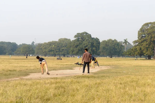 Los niños indios locales se divierten jugando juego de cricket en el área de Maidan en el atardecer de invierno, cerca del estadio Eden Gardens, ciudad de la alegría, Calcuta, Bengala Occidental, India Asia mayo 2019 — Foto de Stock