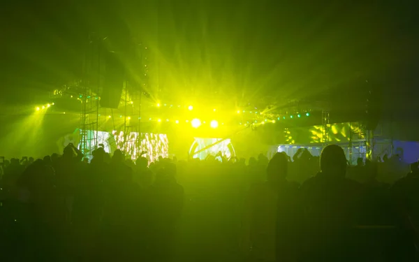 Зрители силуэта толпы людей, стоящих на концерте выступление поп-рок музыкальной жизни церемонии награждения событие перед зеленым цветом сцены света и наслаждаются поднимая руки вверх в воздух перед группой . — стоковое фото