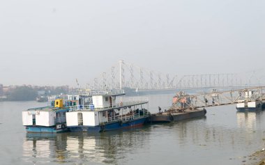 Hooghly nehri üzerinde güneş batarken Muhteşem Howrah Köprüsü. Fotoğraf: Millennium Eco Turizm Parkı Riverside bölgesinde akşam vakti. Kolkata Batı Bengal Hindistan Asya Pasifik Ocak 2020 Mayıs 2019.
