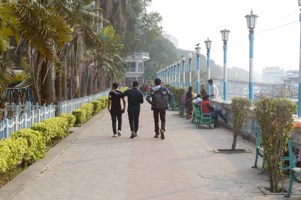 Amigos caminhando ao longo do calçadão na calçada da rua em uma noite tranquila e relaxada no Millennium Eco Tourism Park e área de embelezamento recreativo Riverside. Kolkata Índia Ásia Pac maio 2019 . — Fotografia de Stock