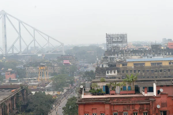 Vista aerea sul tetto della città di Calcutta vita Hooghly fiume Burrabazar zona vicino al ponte Howrah (Rabindra Setu) in una nebbiosa giornata serale invernale. Kolkata West Bengal India, Asia meridionale Pac gennaio 2020 — Foto Stock