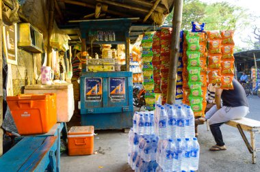 Geleneksel bir Hint ambalajlama yiyecek ve içecek marketi su şişesi, soğuk içecek şişesi, patates cipsi, yol kenarı caddesinde yaz aylarında paketlenmiş içecek sergiliyor. Kolkata Hindistan Güney Asya Mart 2020