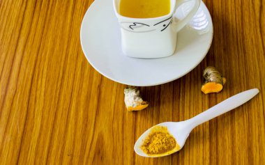 Masa kaşığı saf zerdeçal Haldi tozu. Haldi zerdeçal süt tarifi. Coronavirus Anti viral gıda ve içecek geçmişi. Sağlık hizmetleri için beslenme desteği. Ayurveda ev hapları. Sağlıklı yaşam biçimleri.