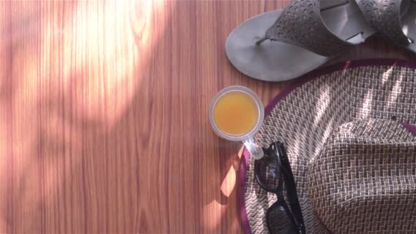 准备好旅行了顶级观赏海滩背景的现代女用木制餐桌装饰品 太阳镜 沙袋和一杯柠檬汁 左边的文字空间 — 图库视频影像