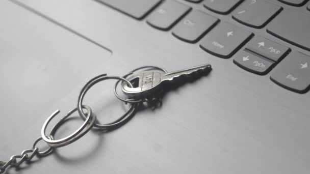 Detailní záběr zátiší kroužku klíčů na klávesnici notebooku. Koncepční obraz zobrazen jako síťový zabezpečovací klíč. Koncepce kybernetické bezpečnosti, ochrany a soukromí.