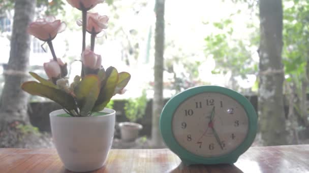 Ένα Βάζο Λουλούδια Και Ένα Ξυπνητήρι Στο Τραπέζι Απομονωμένα Από — Αρχείο Βίντεο