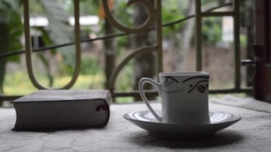 Sabahları bir fincan kahve ve pencere ışığı üzerine bir kitap. Sosyal uzaklık döneminde yeni bir şey keşfetmek için bir romanı bitirme zamanı. Evde kal. Tatil tatili ve sağlıklı bir yaşam tarzı..