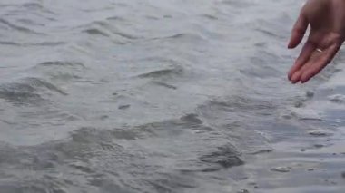 Turist bir kadının elini nehrin su yüzeyine değdirip yaz tatilinde tekne gezintisinin keyfini çıkarırken su damlatırken yakın çekim..