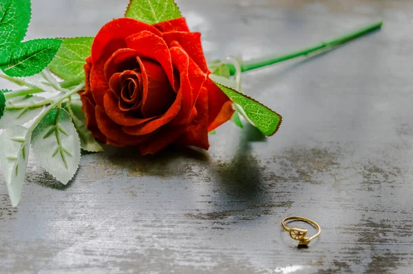 在质朴的金属地板上关闭金订婚戒指饰物 柔和的焦点 浪漫的红玫瑰 情人节和节假日的求婚或求婚概念 复制空间 — 图库照片