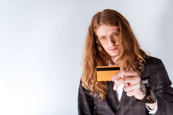şık dövmeli kıvırcık saçlı gösteren kredi kartı ile işadamı