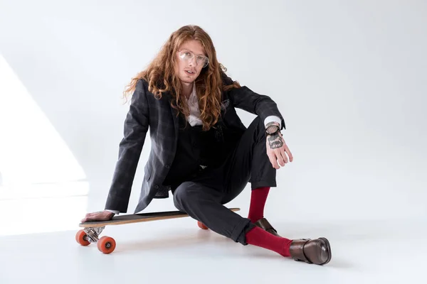 kıvırcık saçlı longboard üzerinde oturan şık iş adamı